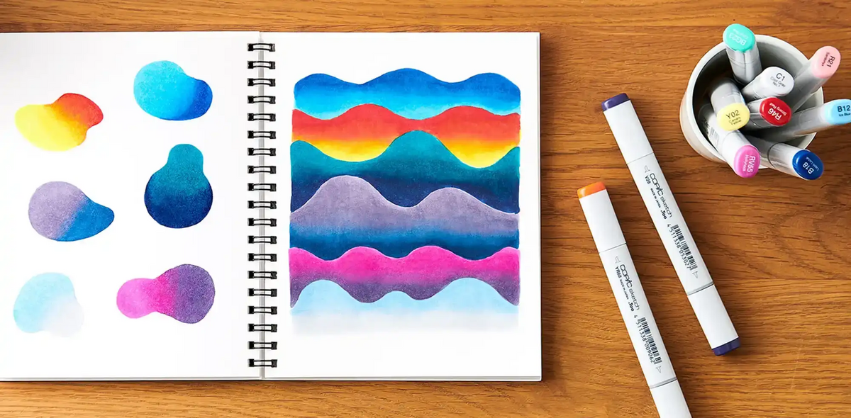 A spiral-bound sketchbook open to pages with colorful marker drawings.