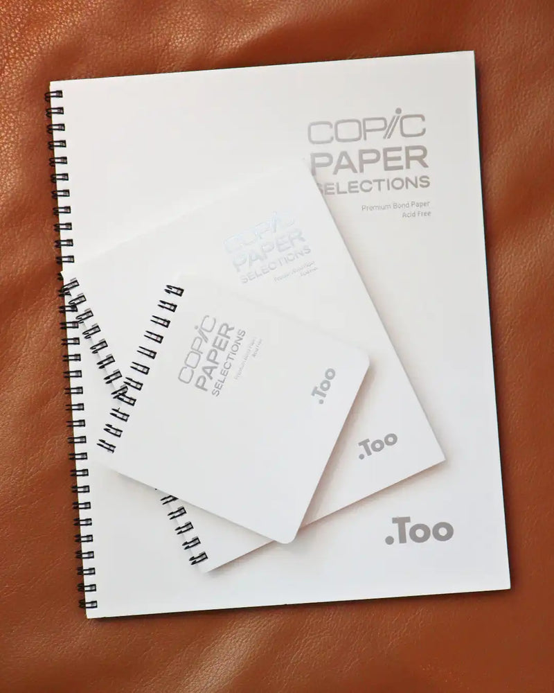 A stack of white spiral-bound paper sample books.